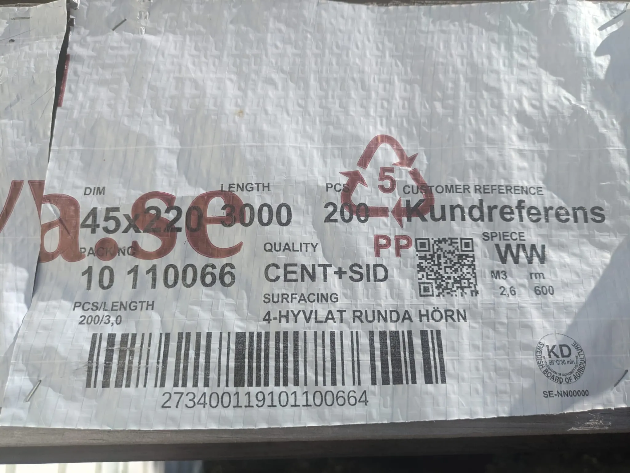 Paketinformation med streckkod och QR-kod tryckt på vit emballageplast