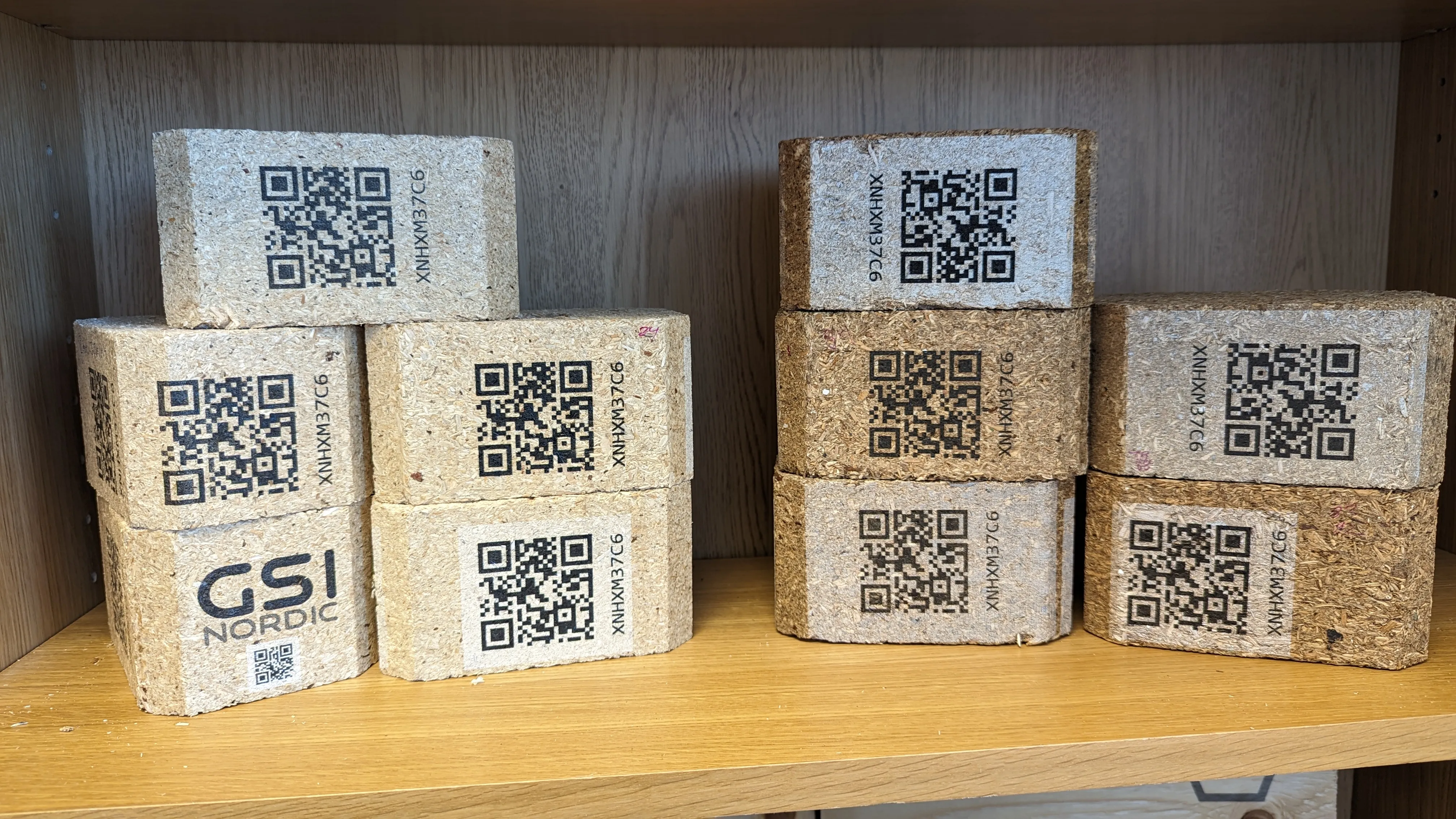 Ljusa och mörka fiberklossar med EPAL-QR-koder i svart respektive svart och vitt