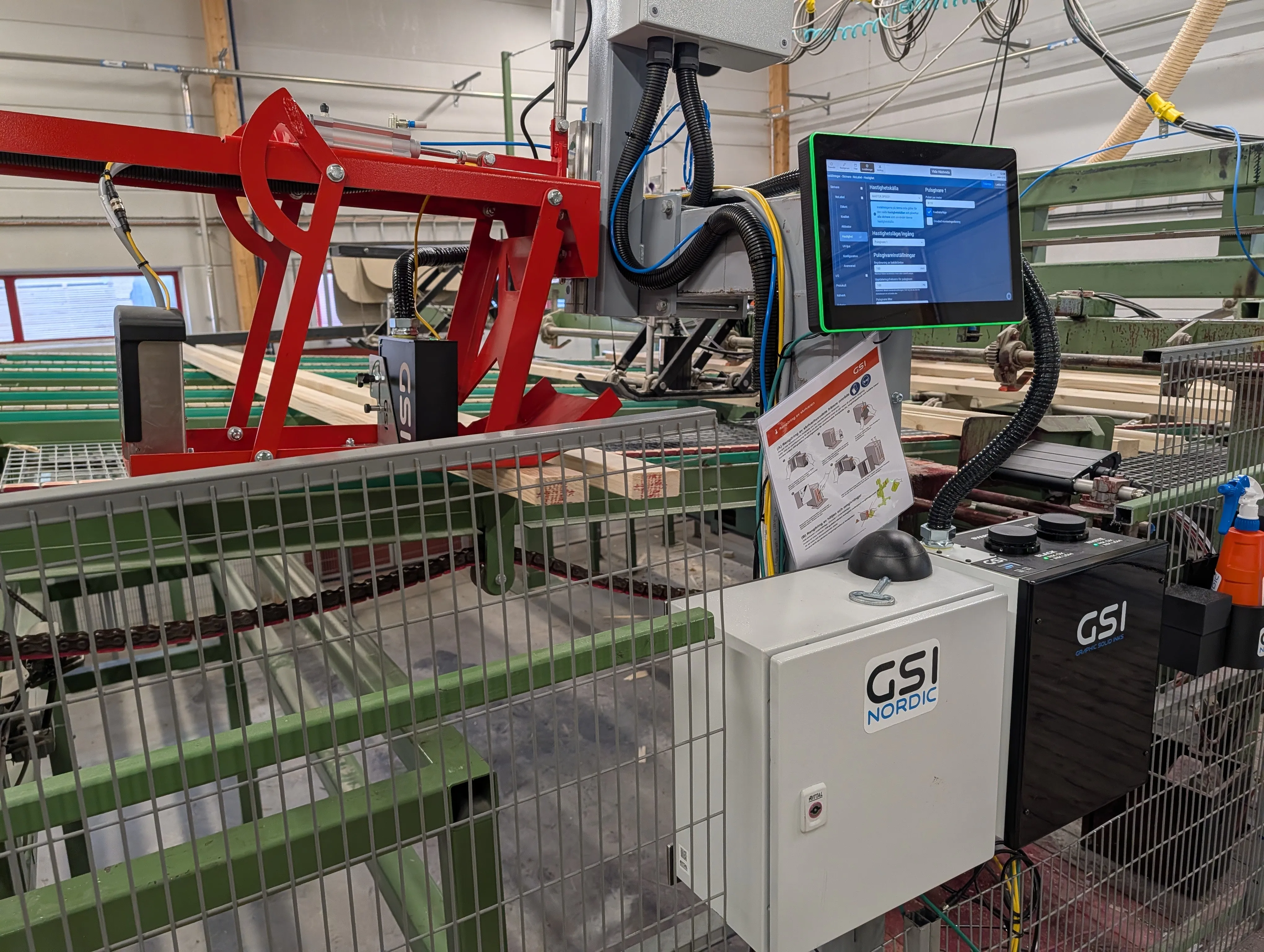 GSI Nordic-skrivare installerad vid en virkeslinje med styrskåp och pekskärm