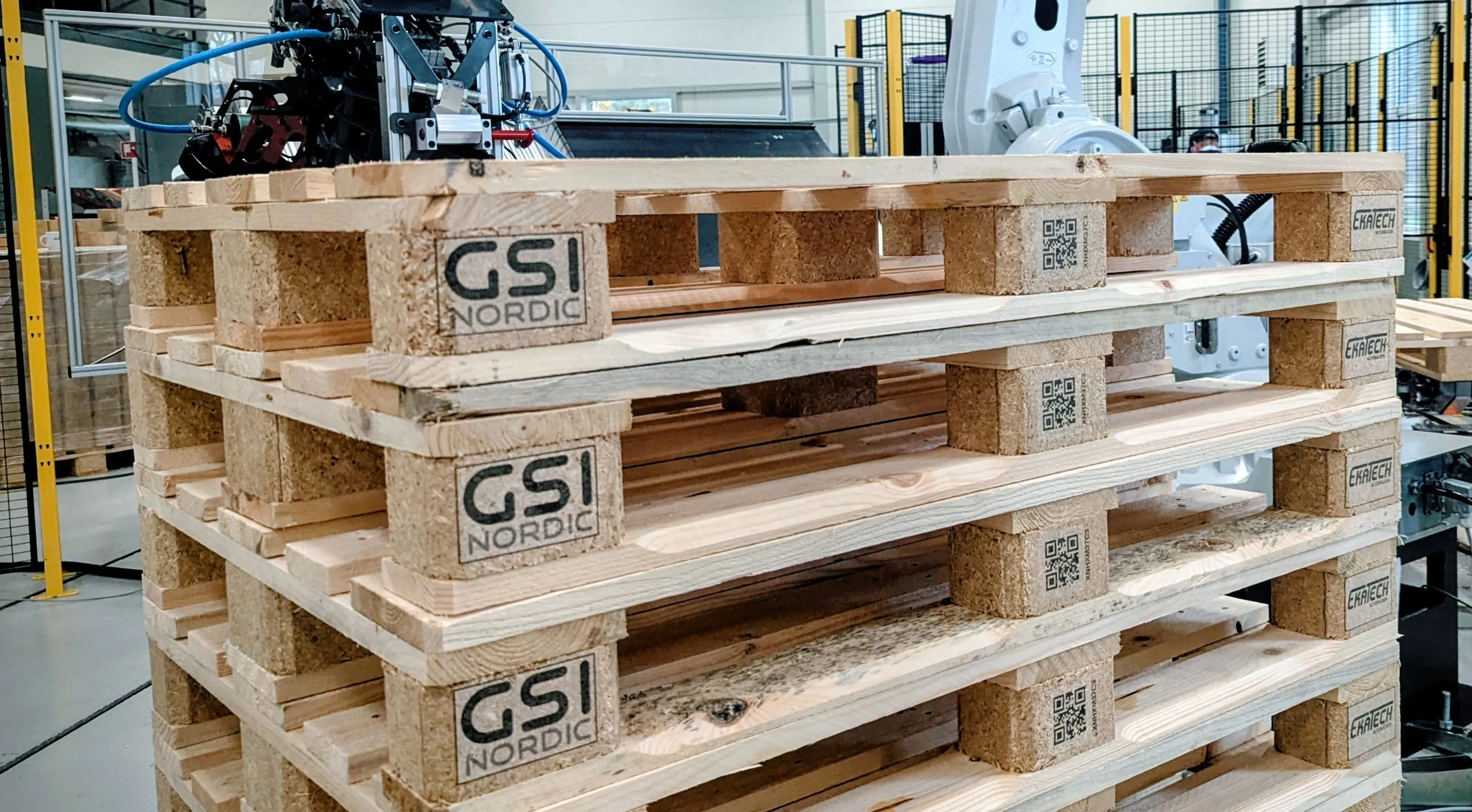 Staplade pallar med GSI Nordic-logotyp och QR-koder tryckta på klossarna