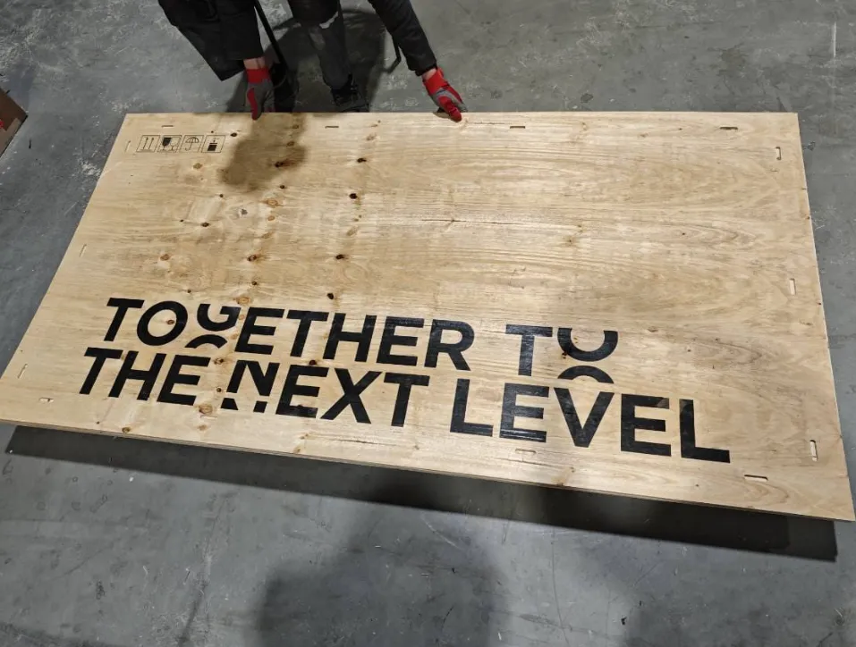 Plywoodskiva med stor svart text tryckt direkt på ytan